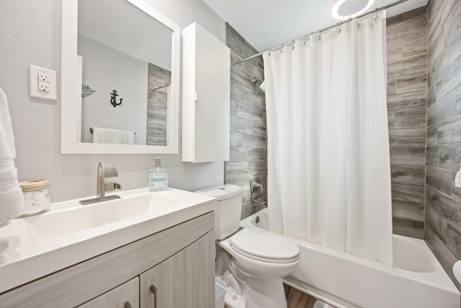 Blue Gecko second bathroom with wood-look tile shower at Gecko House Manasota Key