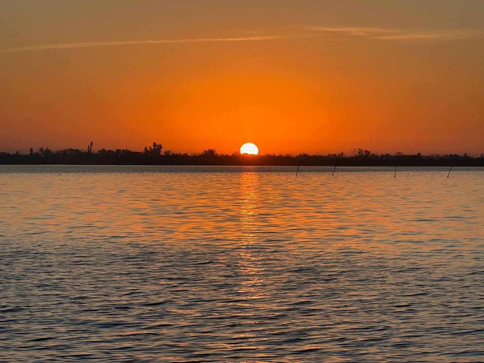 Bright orange sunrise reflecting across Lemon Bay at Gecko House