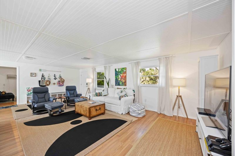 Blue Gecko open living room with white beadboard ceiling at Gecko House, Manasota Key
